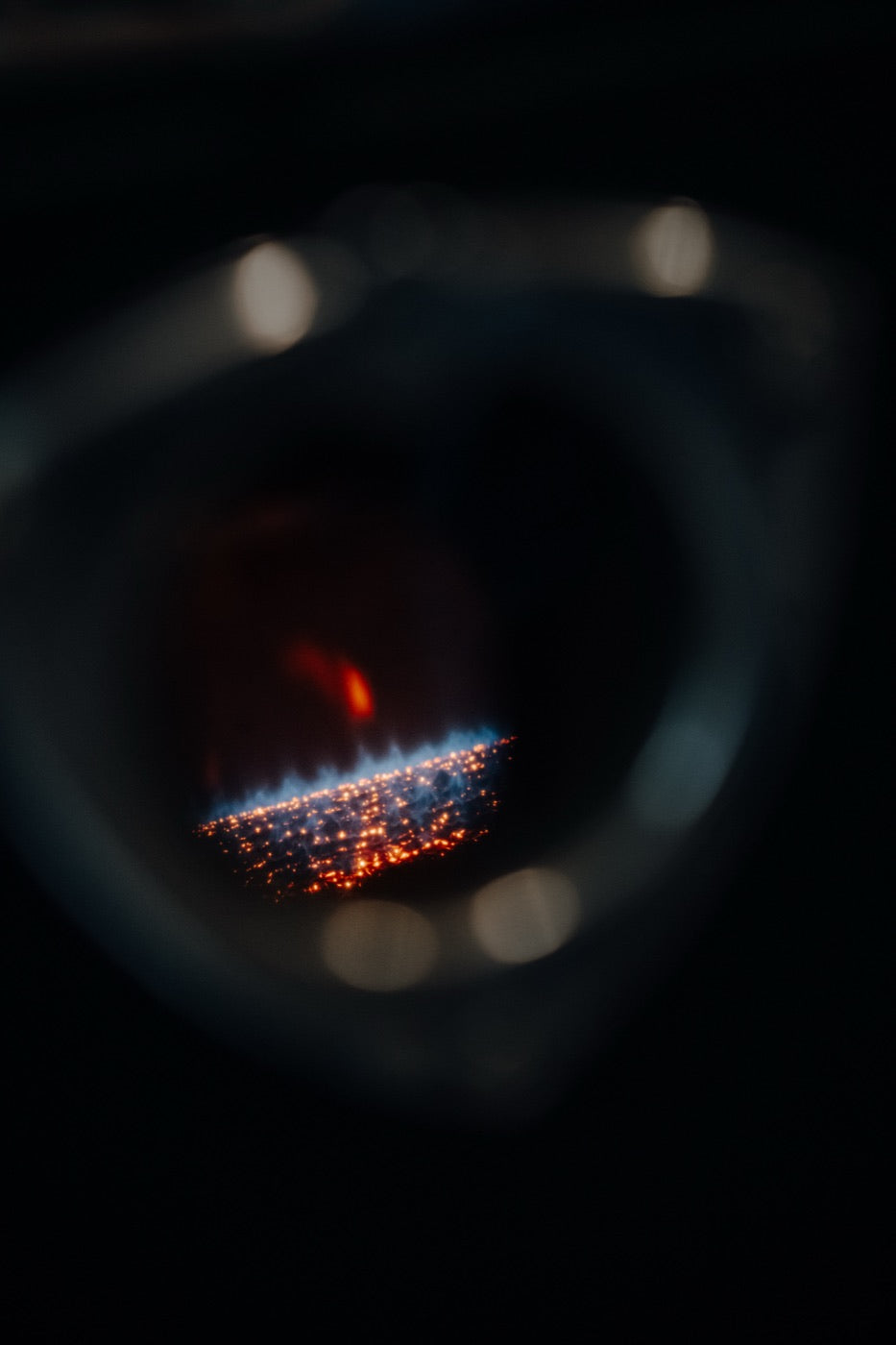 Blick durchs Schauglas auf die Flamme im Röster